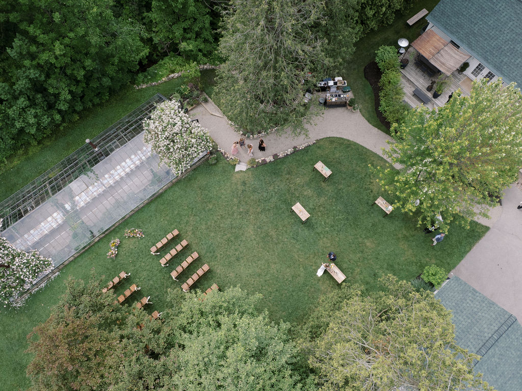 Aerial view of the ceremony setup, cocktail hour, and greenhouse reception space at Glass House Community