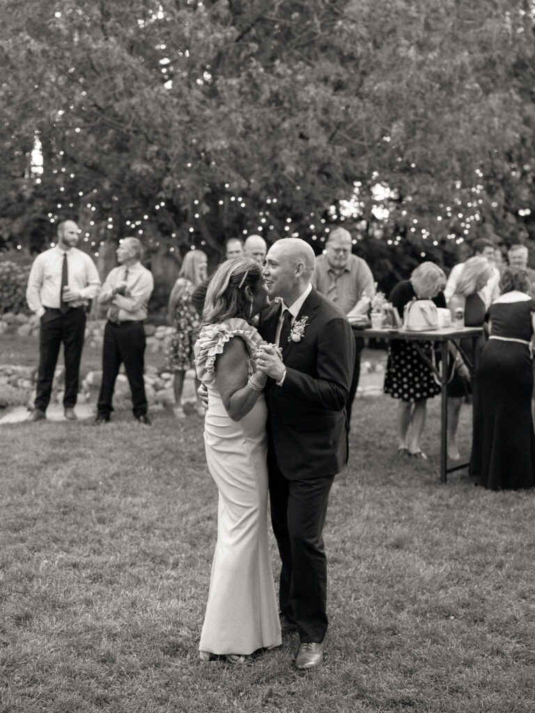 Black and white photo of the groom dancing with his mother during his Glass House Community wedding reception