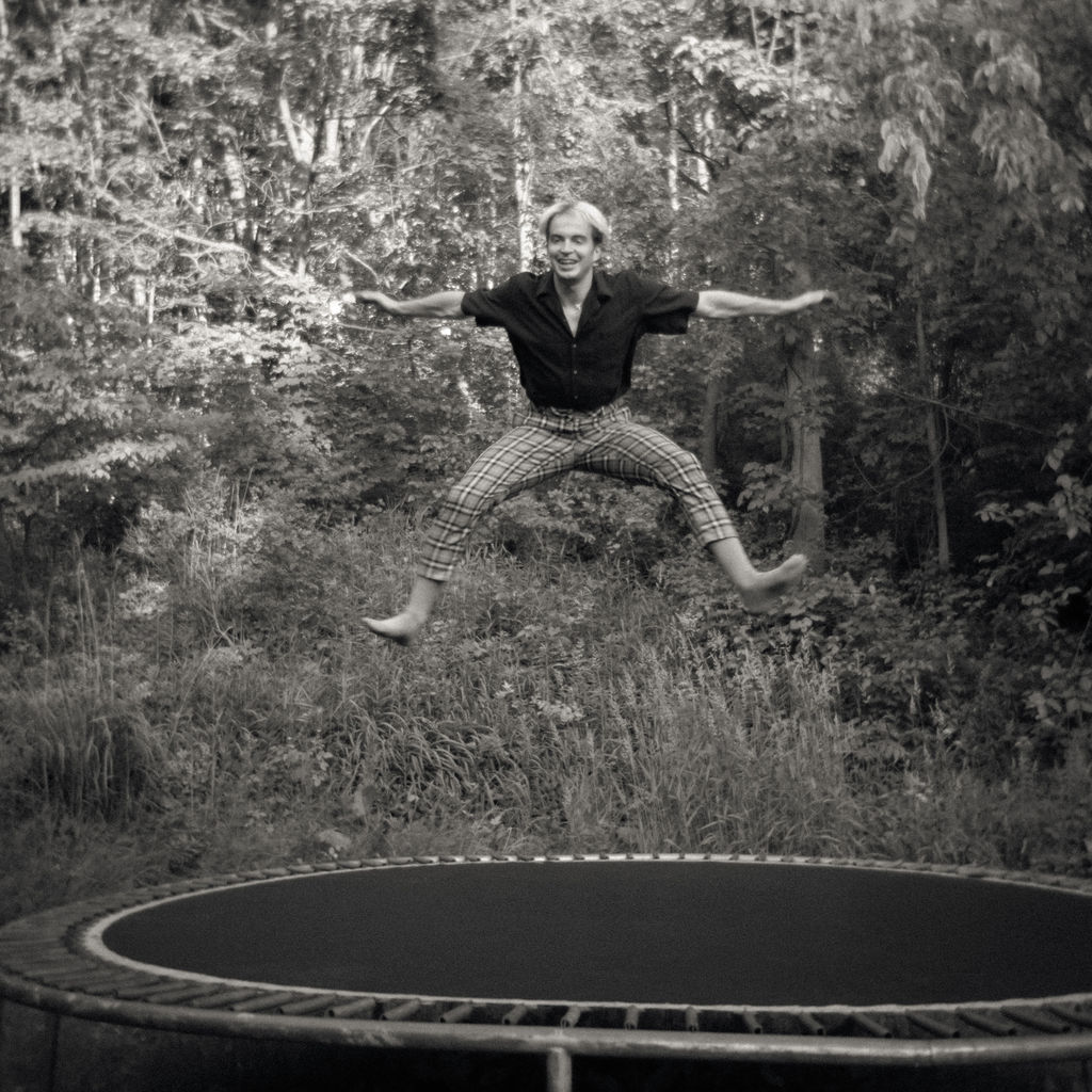 Black and white photo of a guest jumping on a trampoline