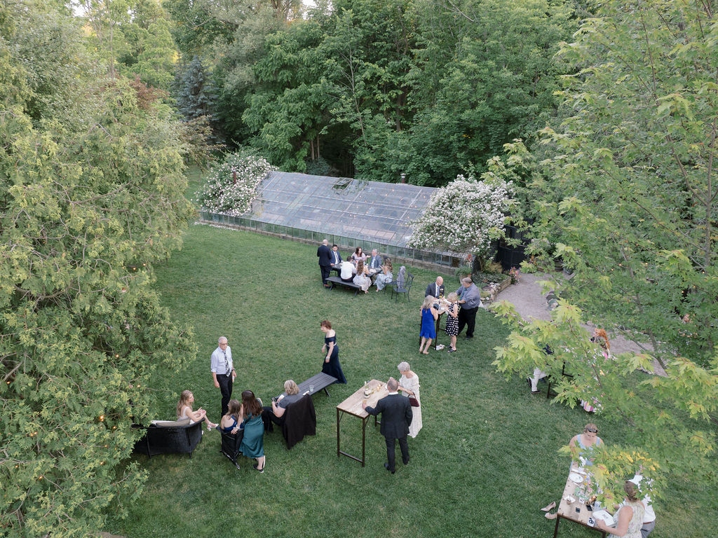 Aerial view of guests mingling outside The Glass House Community during cocktail hour.