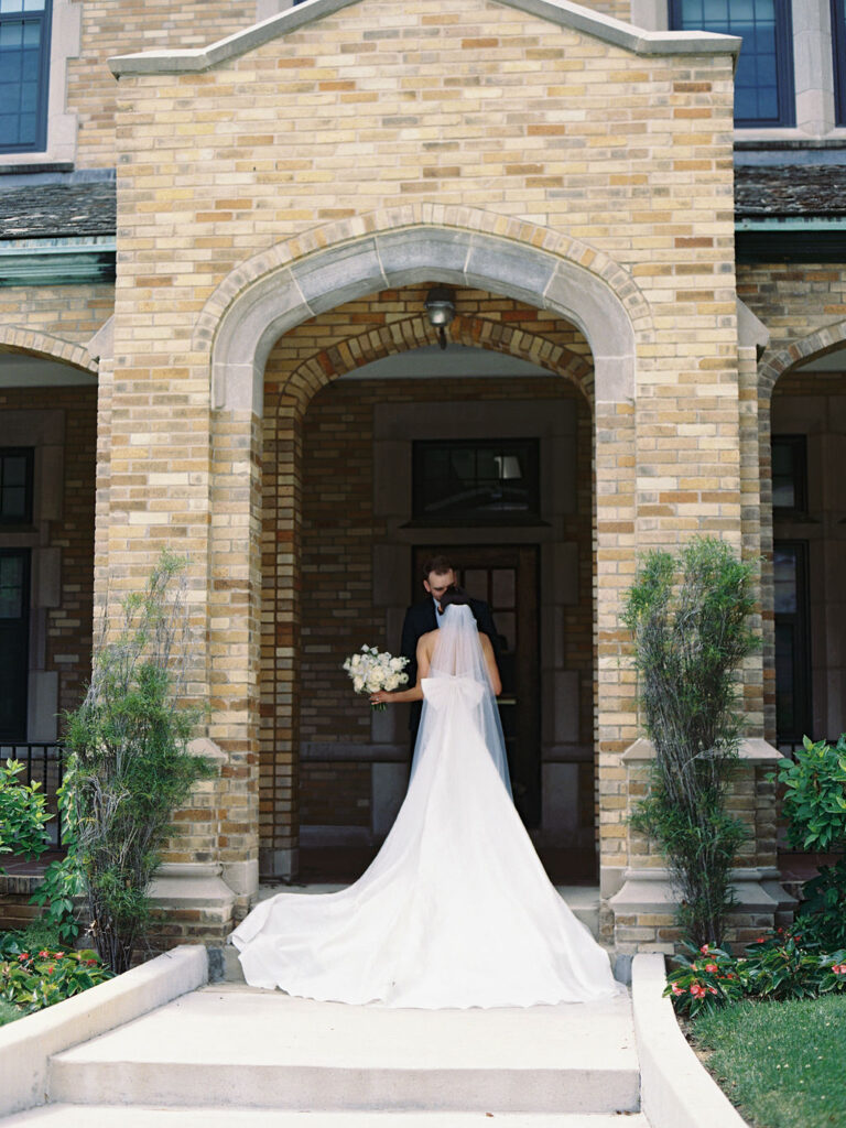 Bride and groom kissing in a doorway during their Saint Mary's Notre Dame wedding photos