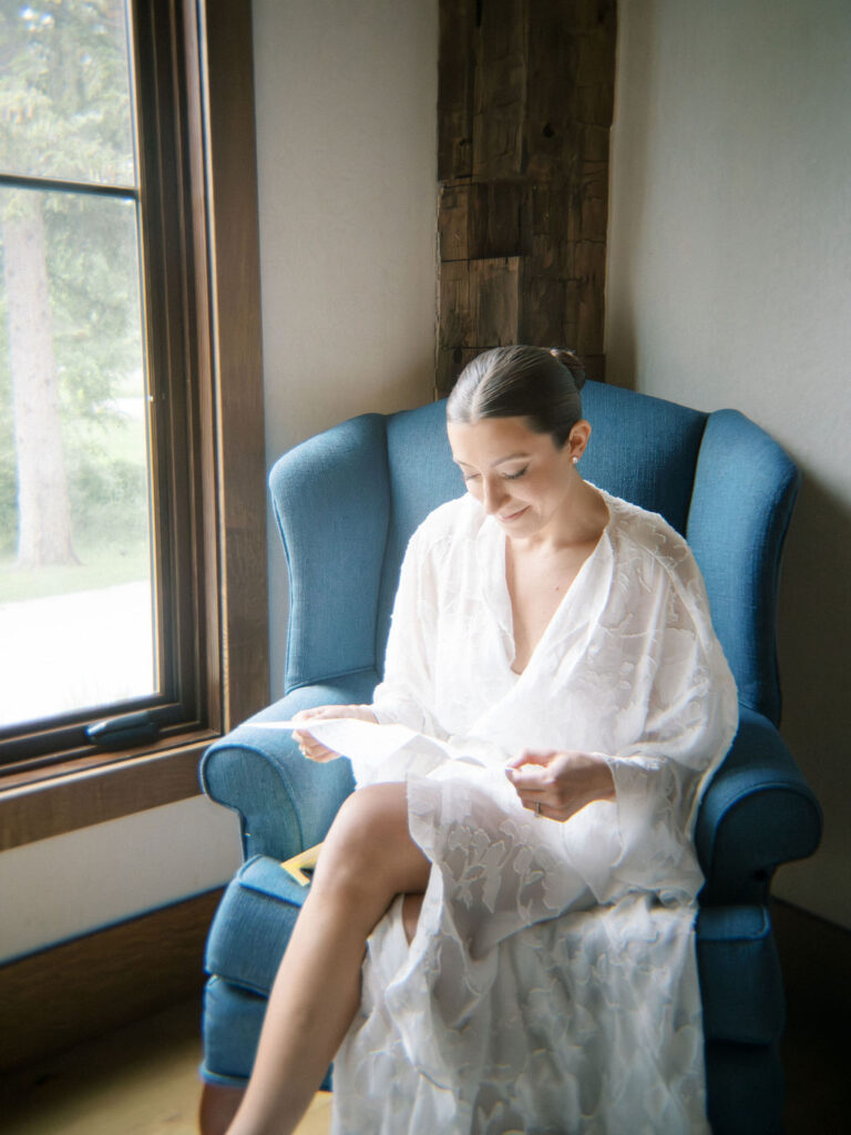 Bride reading handwritten note while getting ready in soft morning light at Saint Mary’s College – film image by Cynthia Mae Photo.