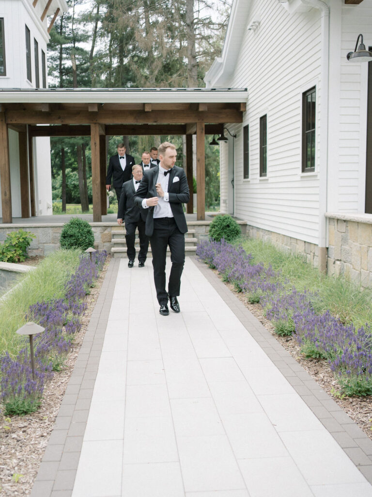 Groom and his groomsmen walking to meet the bride for their first look
