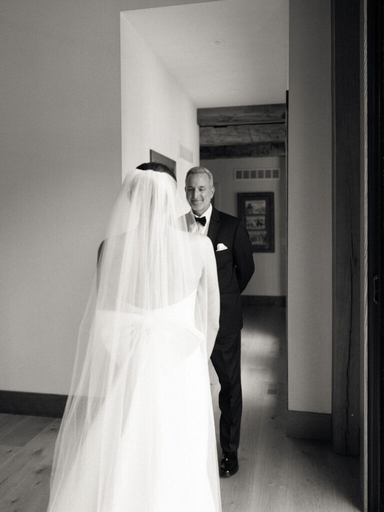 Black and white photo of a bride sharing a first look with her father
