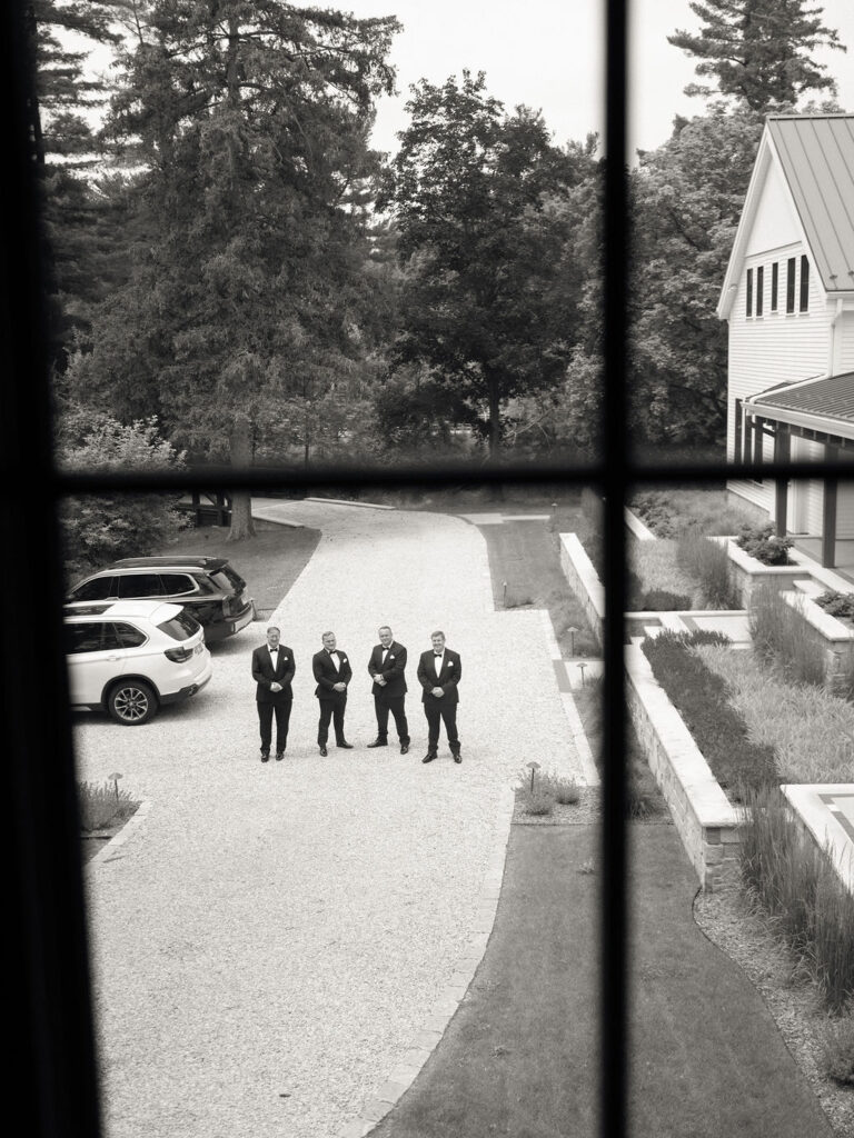 Black and white photo of groomsmen waiting outside