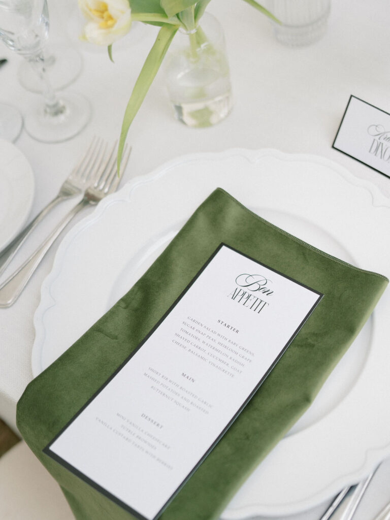 Close-up of menu and green velvet napkin at Saint Mary’s Notre Dame wedding reception table – Cynthia Mae Photo.