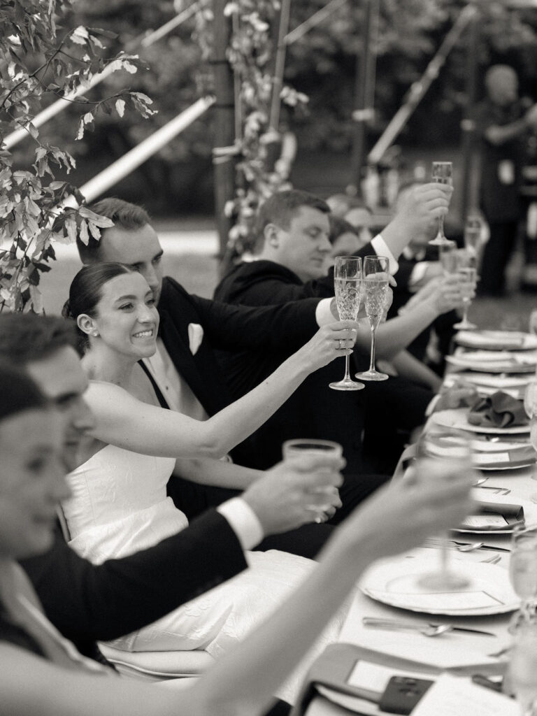 Black and white photo of a bride and groom toasting during speeches