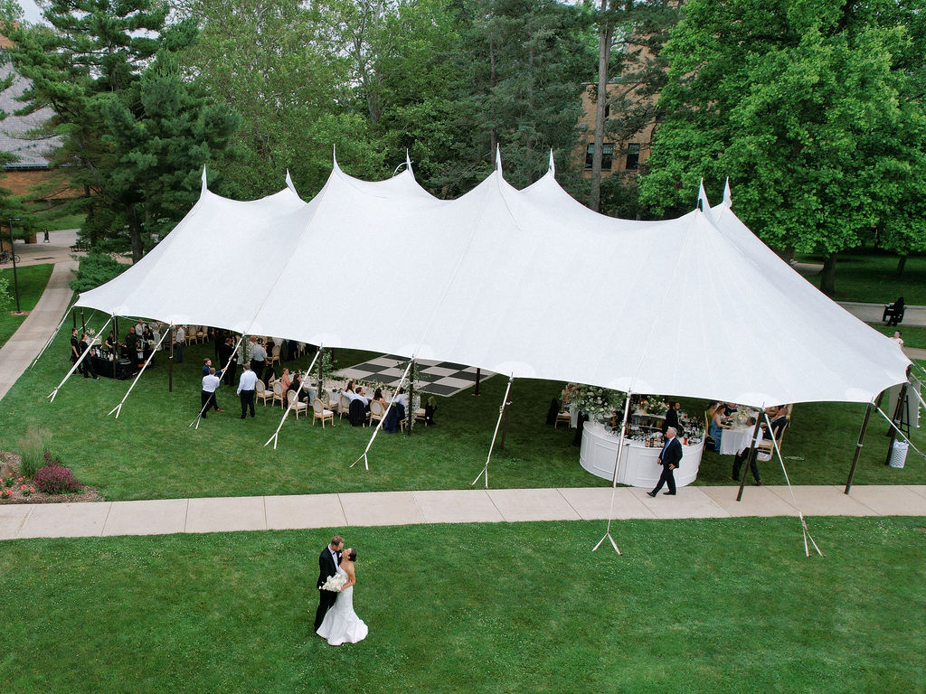Aerial view of sailcloth tented reception behind Le Mans Hall at Saint Mary’s College with bride and groom sharing a private dance outside – Cynthia Mae Photo.