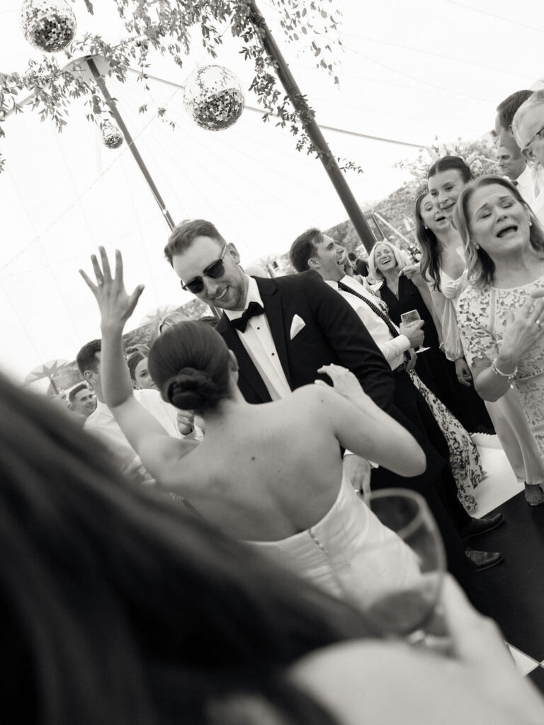 Bride and groom dancing while surrounded by their guests