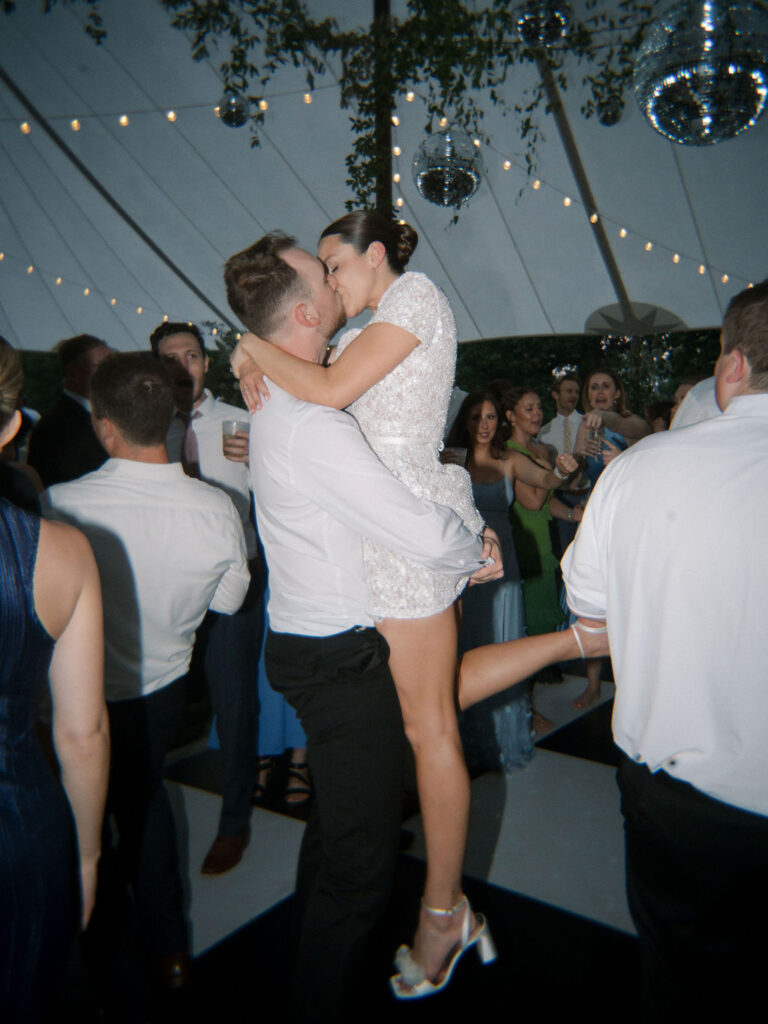Groom lifting and kissing the bride during their reception
