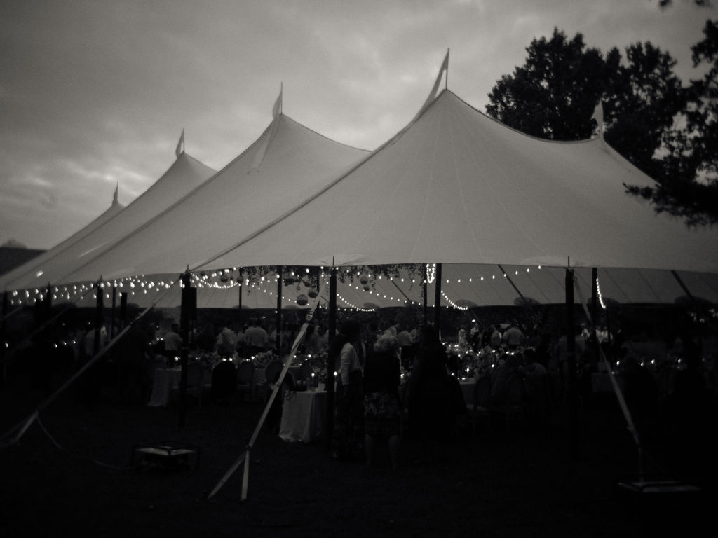 Black and white photo of an elegant tented reception setup behind Le Mans Hall
