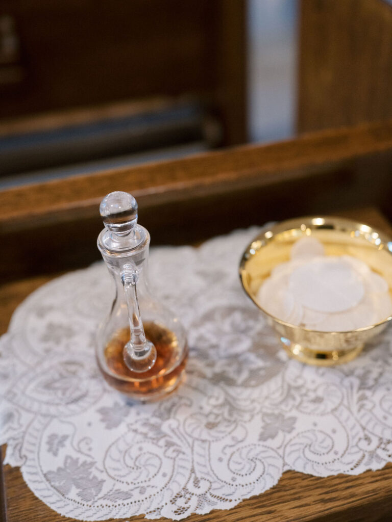 Communion elements with wine and wafers on lace cloth during Saint Mary’s Notre Dame wedding ceremony – Cynthia Mae Photo.