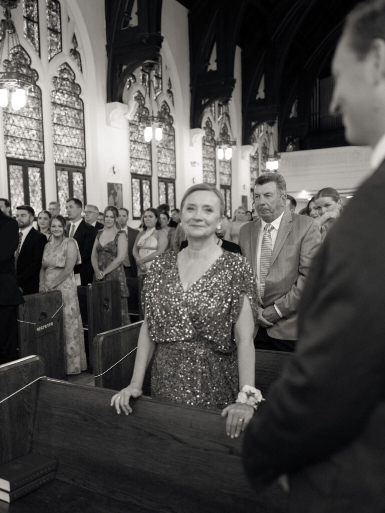 Mother of the bride smiling as the ceremony begins inside Church of Our Lady of Loretto – Cynthia Mae Photo.
