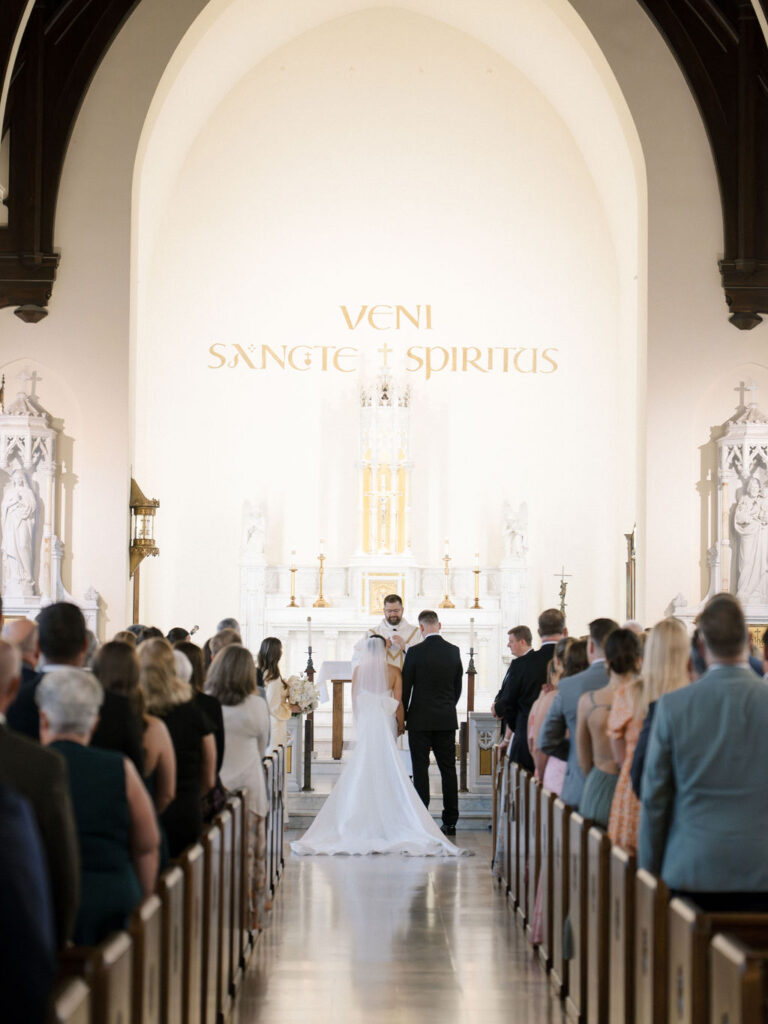 Couple standing together at the altar as priest leads ceremony inside Church of Our Lady of Loretto at Saint Mary’s College – Cynthia Mae Photo.
