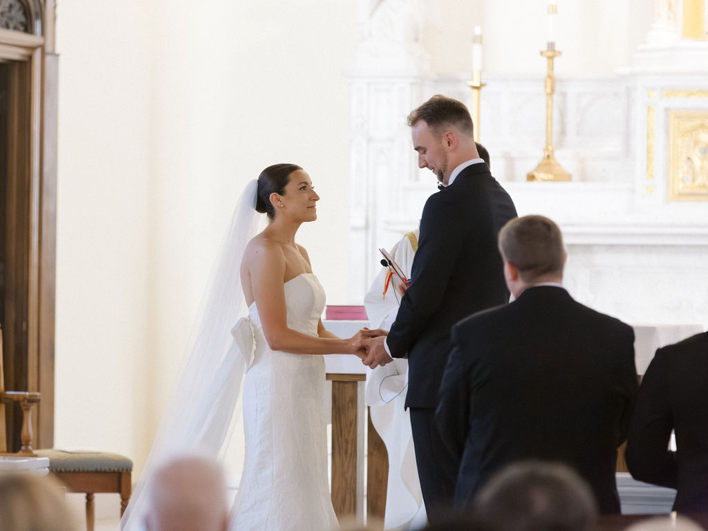 Bride and groom holding hands at the altar