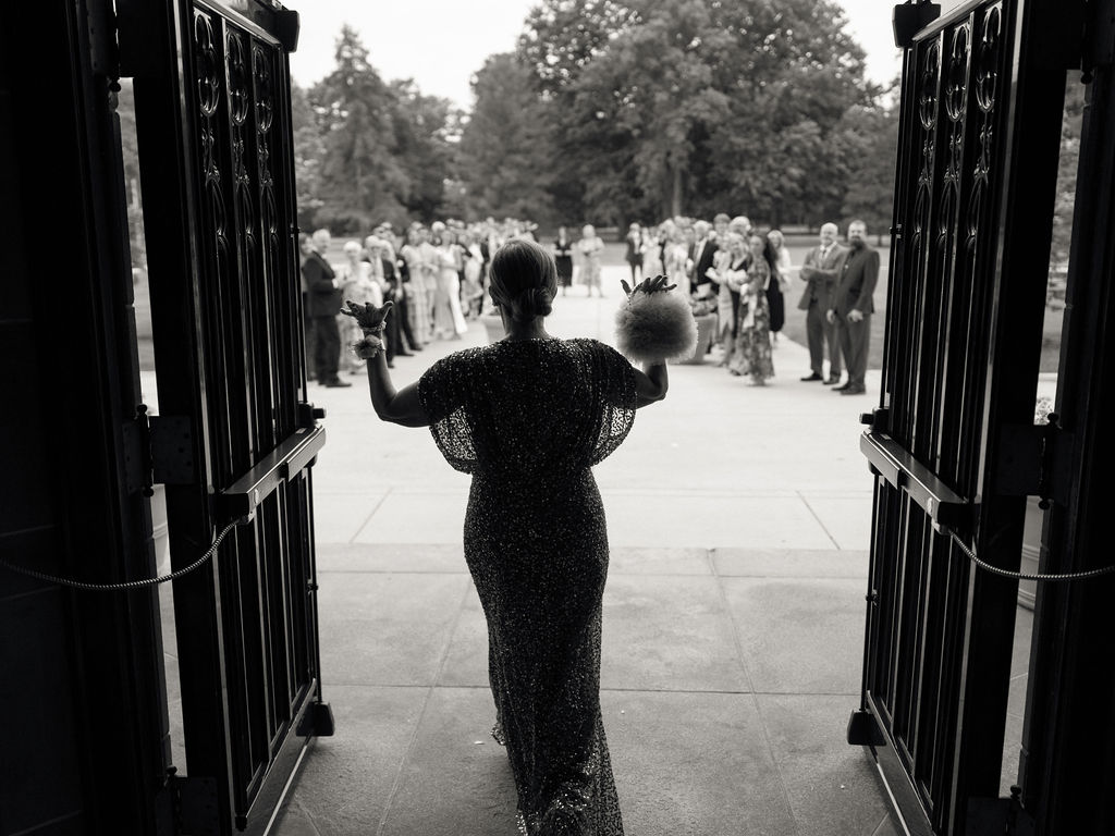 Mother of the bride opening the church doors for the bride and grooms wedding exit
