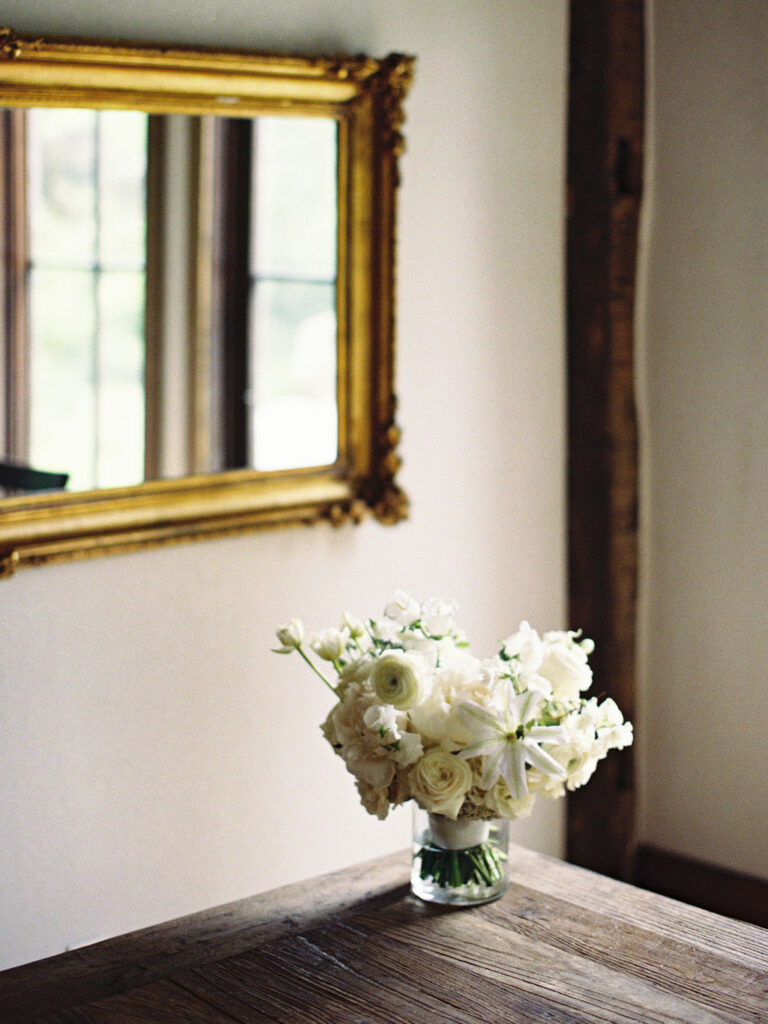 Film photo of a bride classic white wedding bouquet sitting in a vase on a table