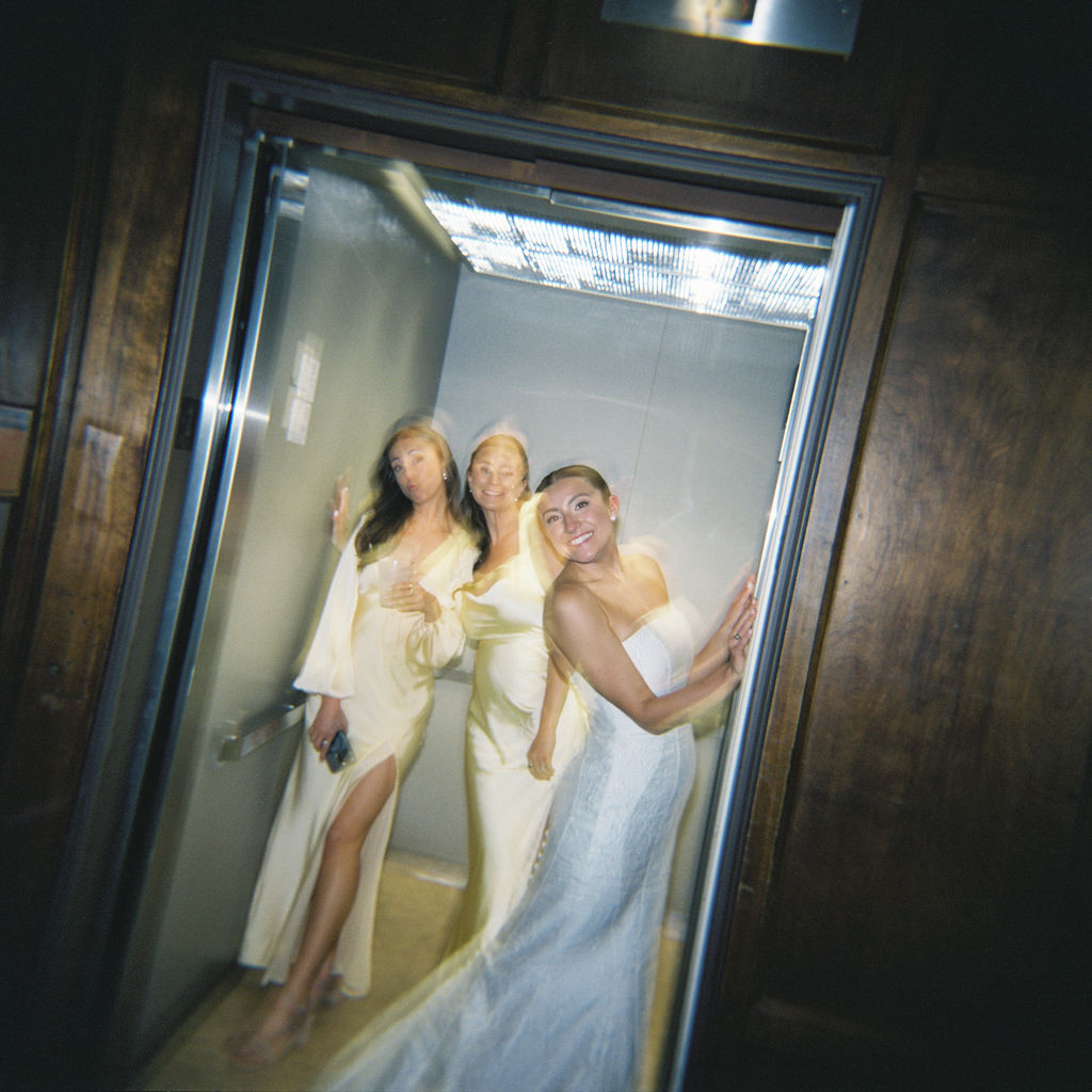Bride and her bridesmaids getting into the elevator