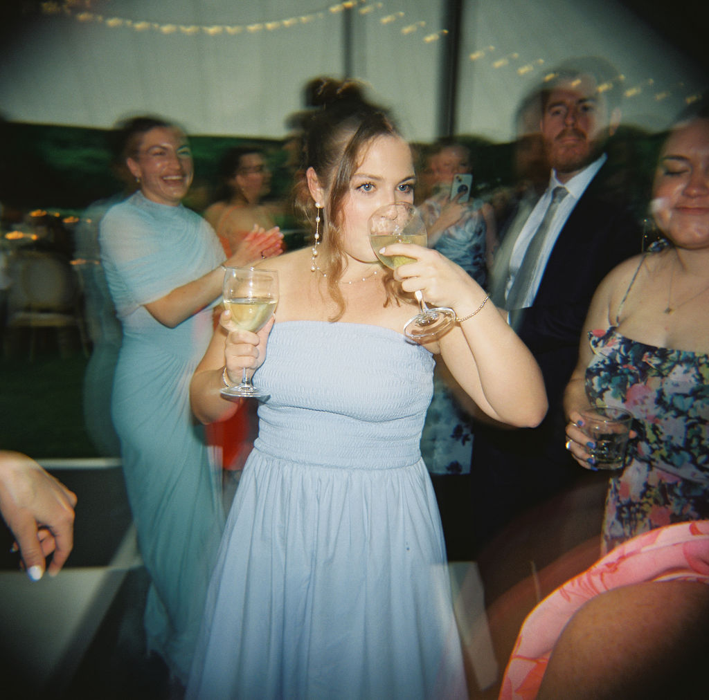 Guest holding two drinks during the reception