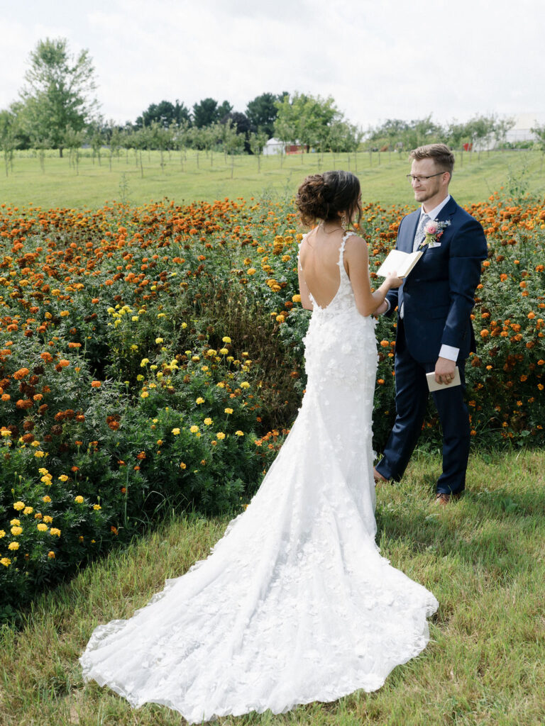 Bride reading her vows to her groom in the gardens.