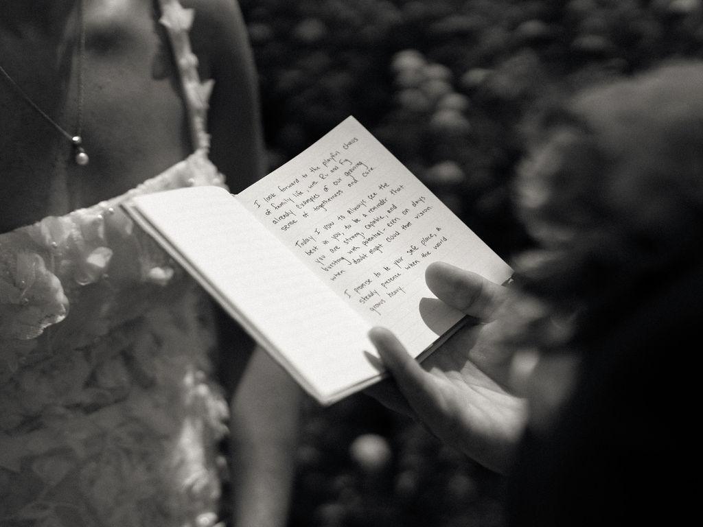 Close-up of handwritten wedding vows being read during private vow exchange at an Of The Land wedding.