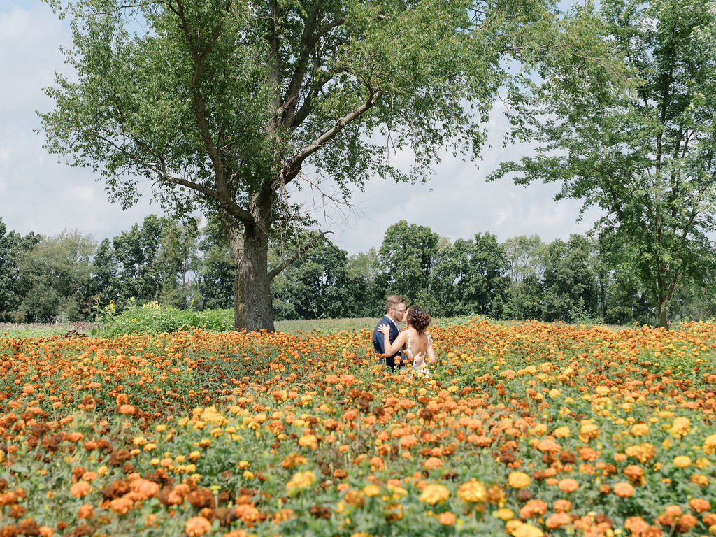 Bride and groom kissing in the gardens at Of The Land wedding venue in Marshall, Michigan.
