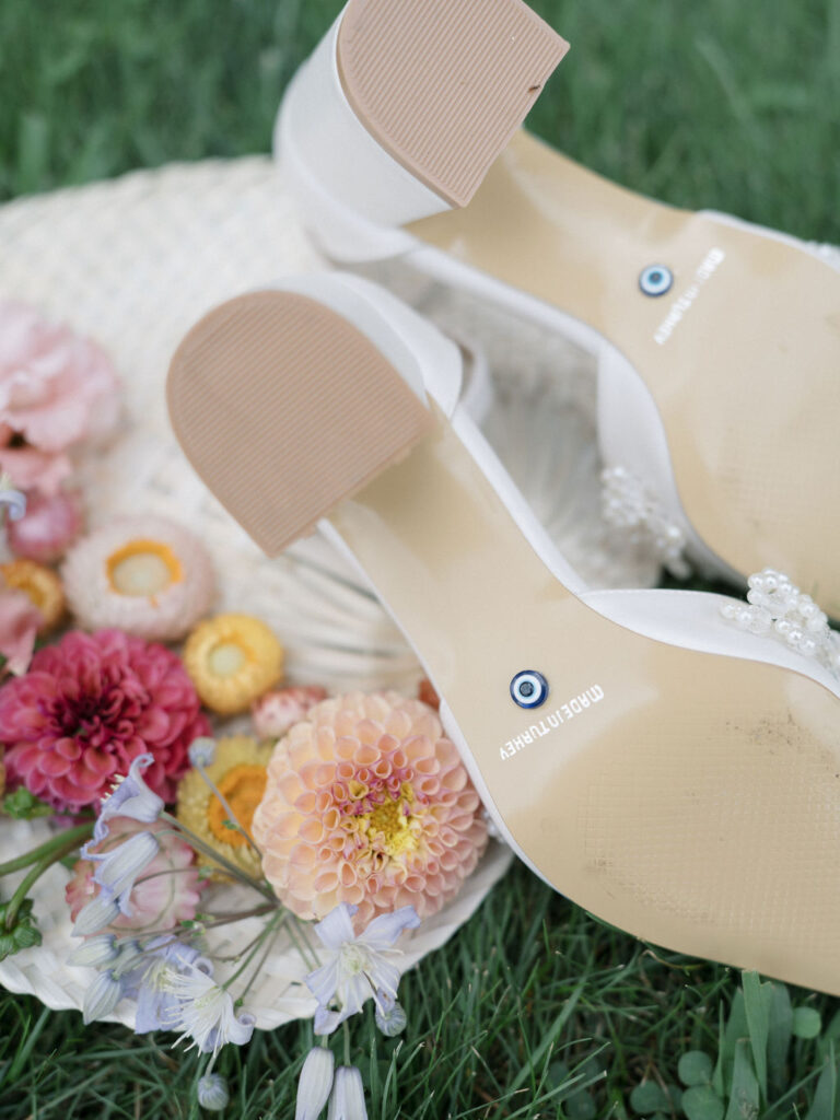 Close up shot of the brides wedding shoes and florals.