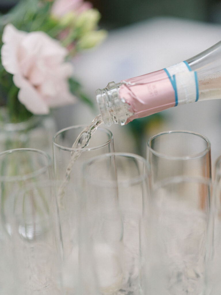 Champagne being poured into glasses during cocktail hour at Of The Land.
