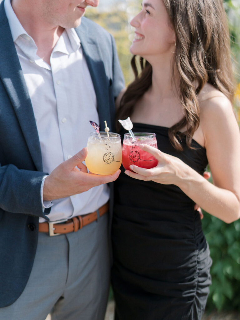 Guests holding colorful signature cocktails during garden cocktail hour.