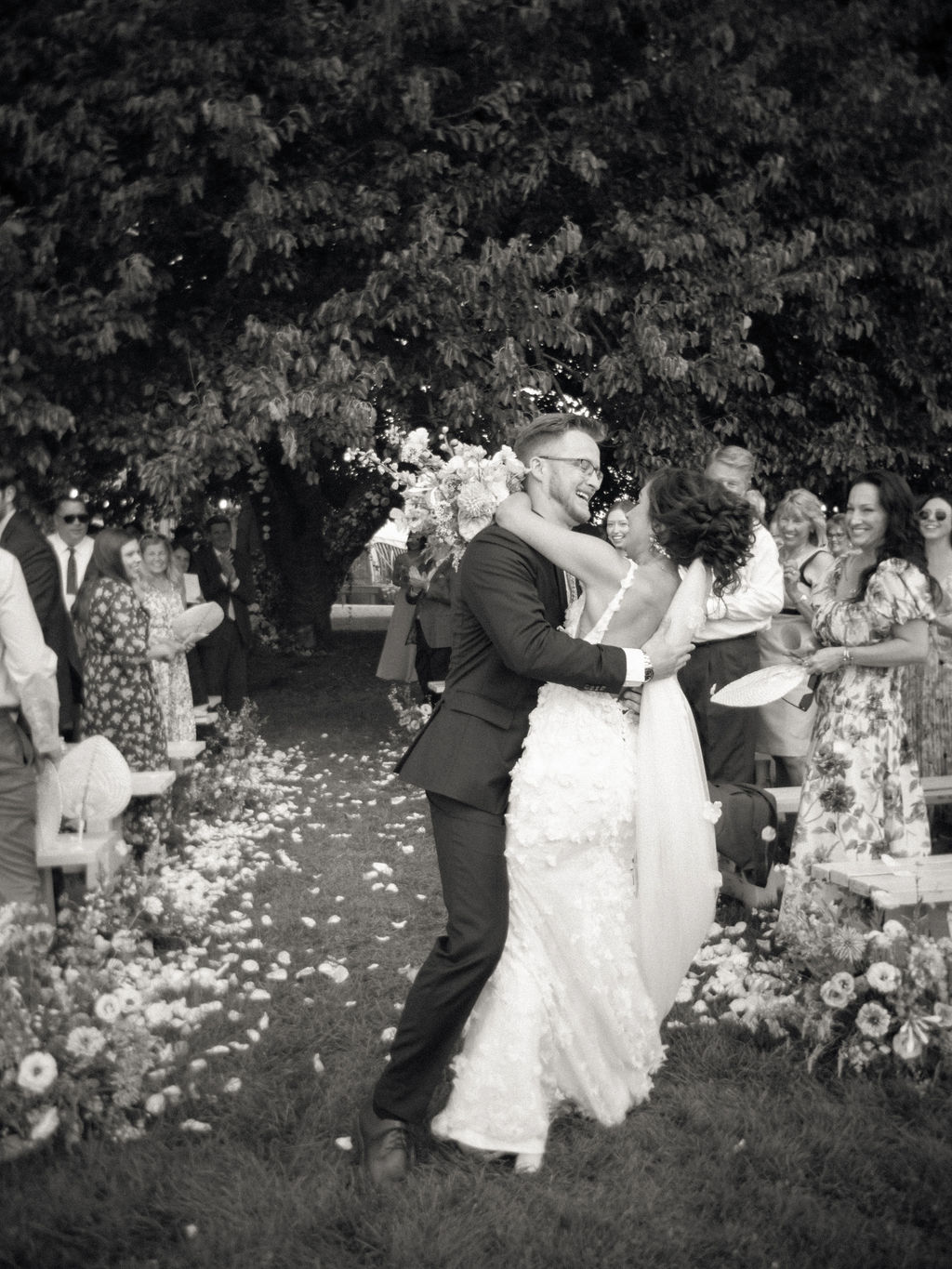 Black and white candid of the couple celebrating during their ceremony recessional.