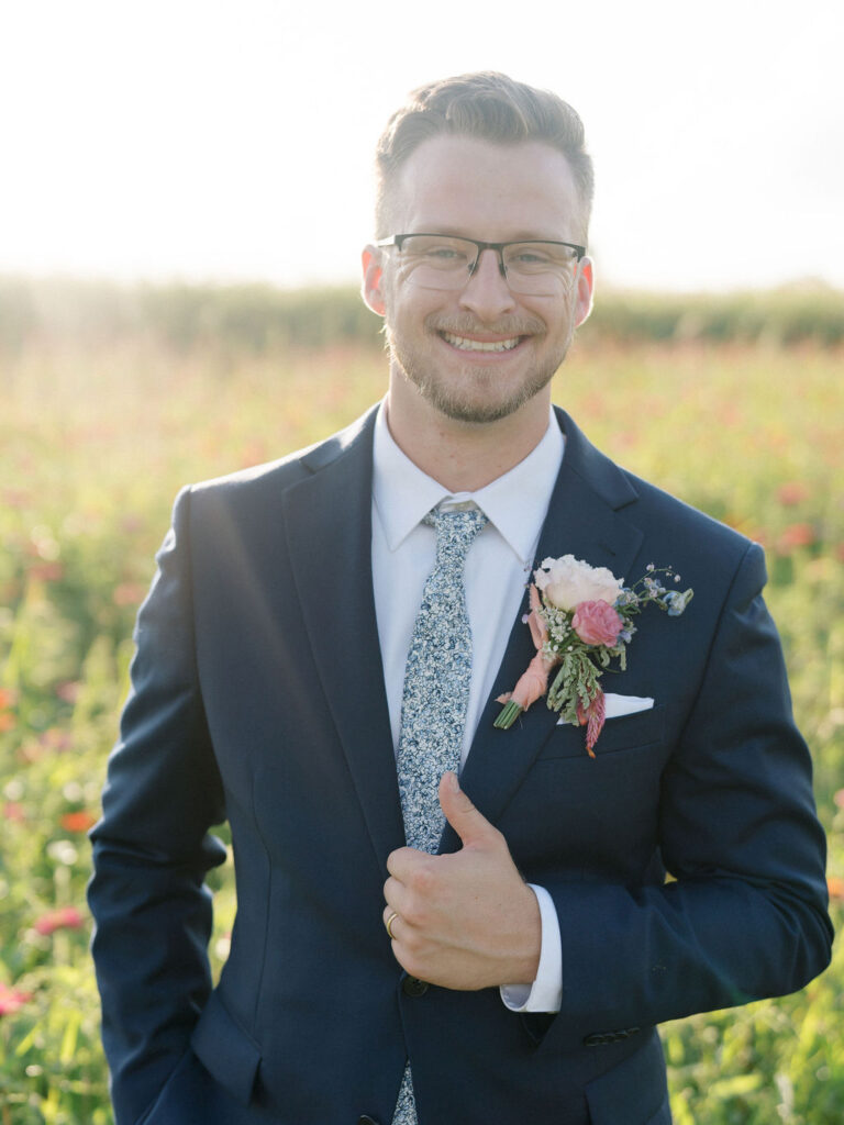 Outdoor golden hour grooms portraits in the meadows at Of The Land wedding venue in Michigan