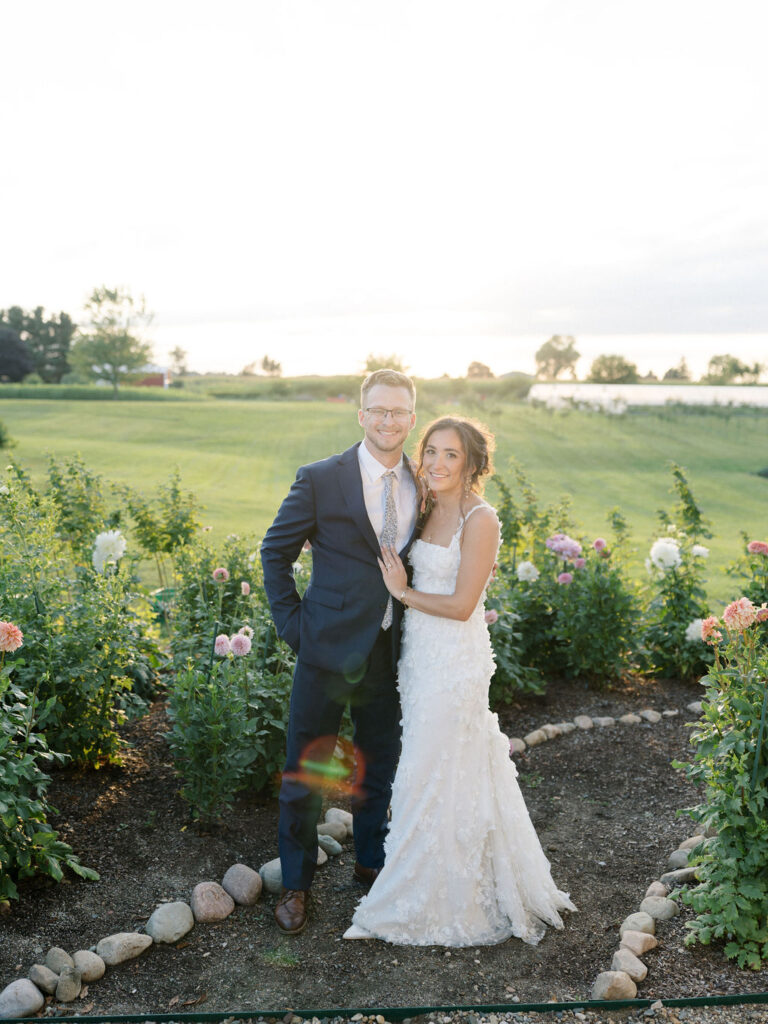 Couple posing together in the meadows at of The Land wedding venue.