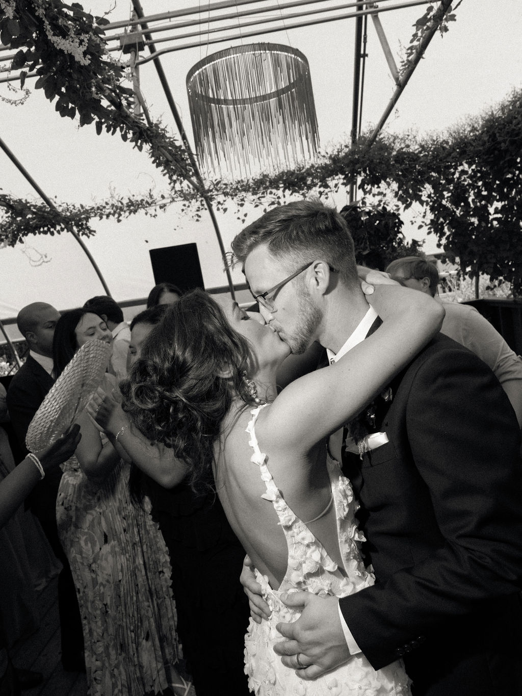 Flash wedding reception photo of the bride and groom kissing after their entrance. 