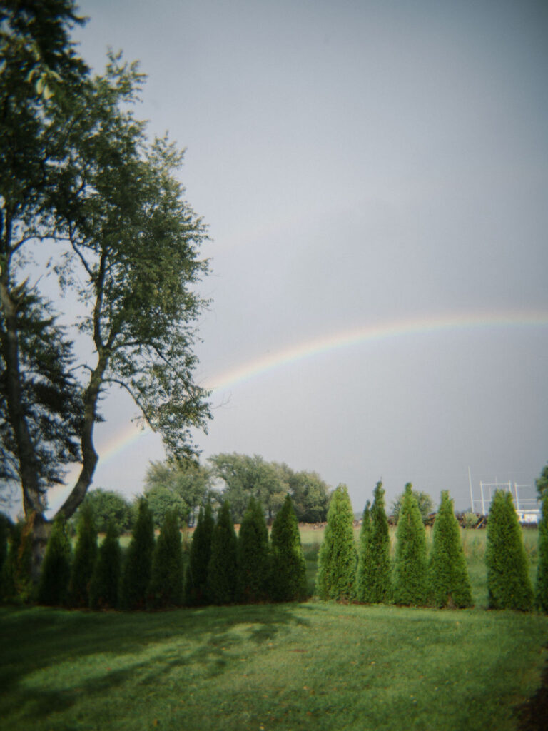 Rainbow in the sky over Of The Land wedding venue in Michigan.