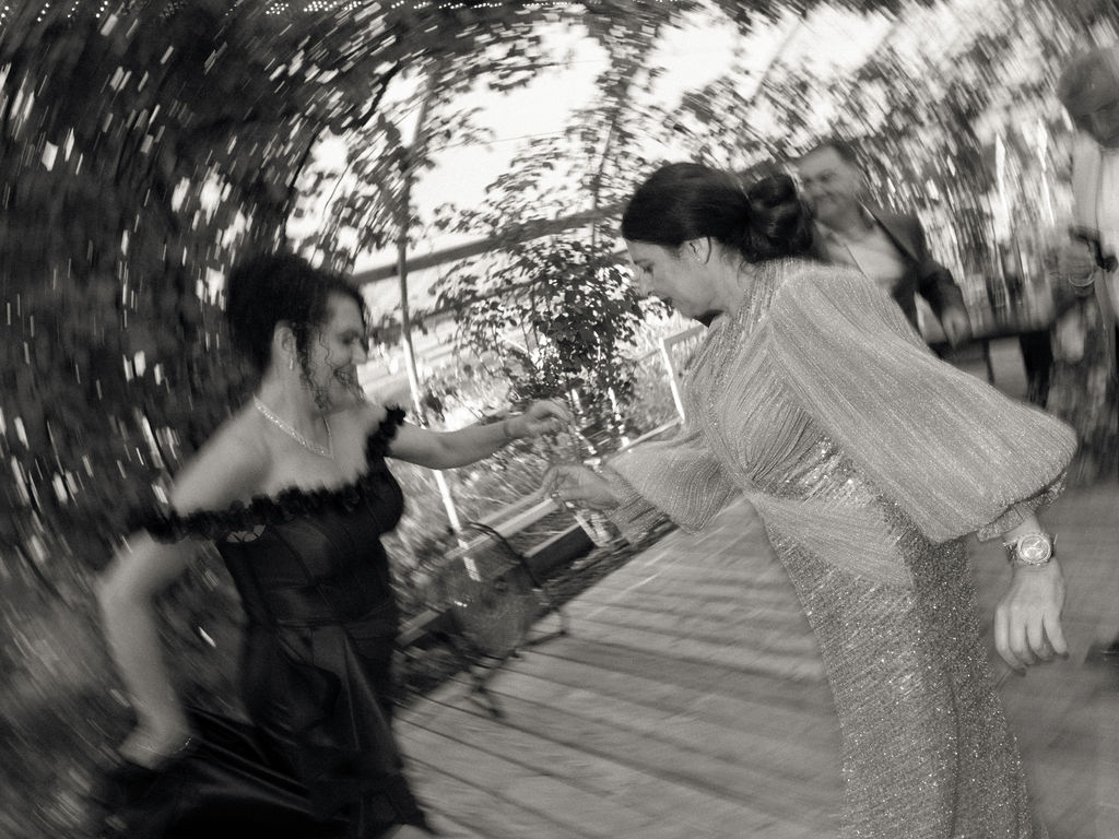 Black and white motion blur photo of guests dancing during the reception.