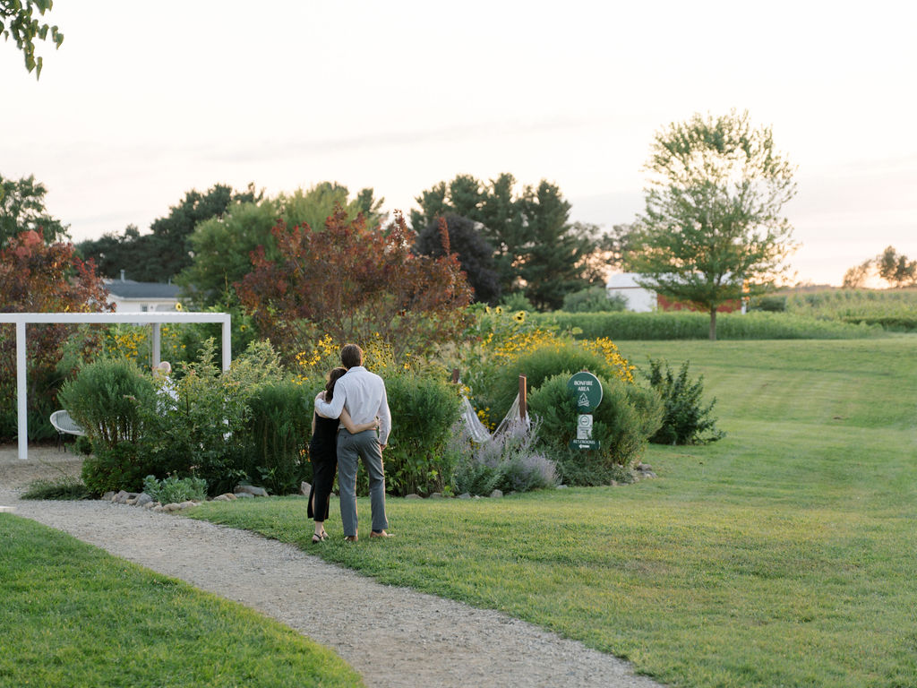 Guests admiring golden hour in the gardens at Of The Land wedding venue.