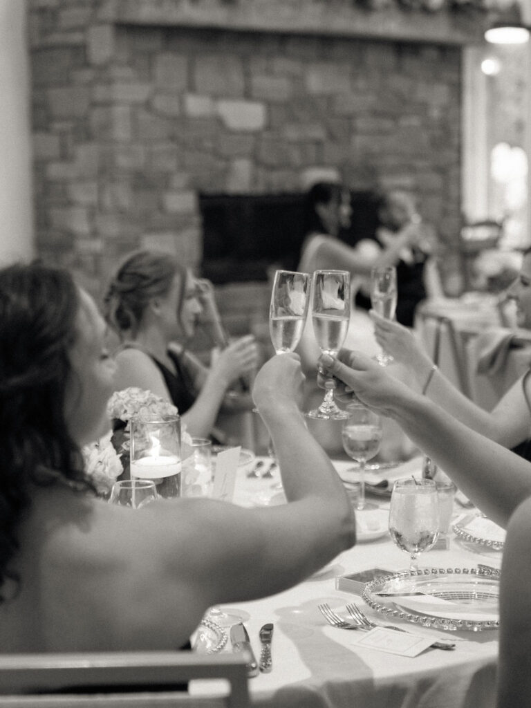 Black and white candid photo of guests toasting their champagne glasses.