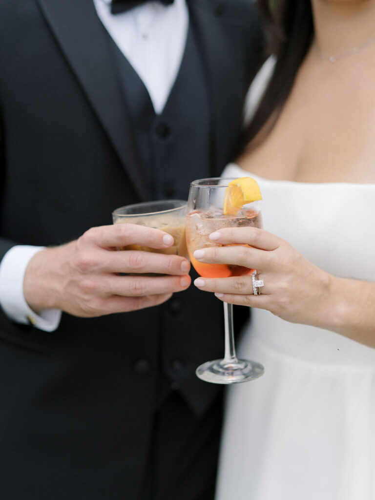 Close up shot of a bride and groom with their drinks during their Bay Pointe Woods wedding cocktail hour.