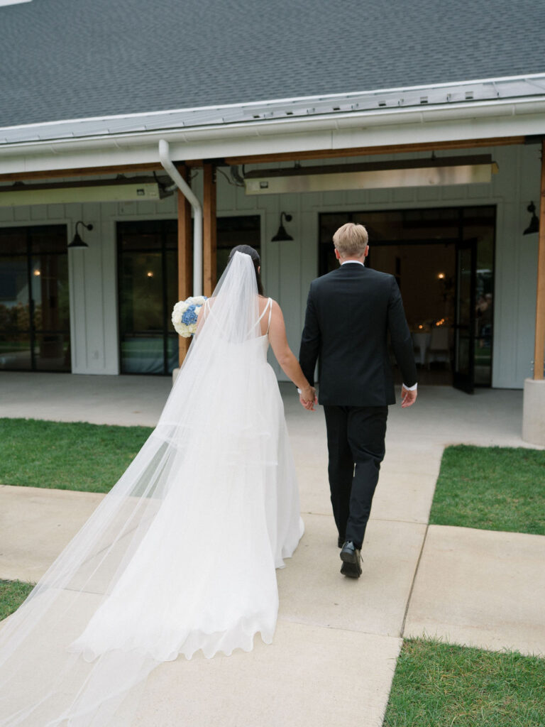 Bride and groom walking back to Bay Pointe Woods wedding venue after their ceremony.