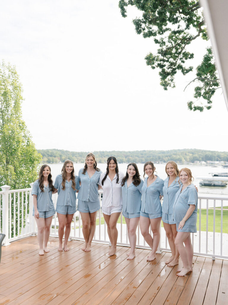 Bride standing with her bridesmaids in matching blue pajamas on the Boathouse Villa deck.