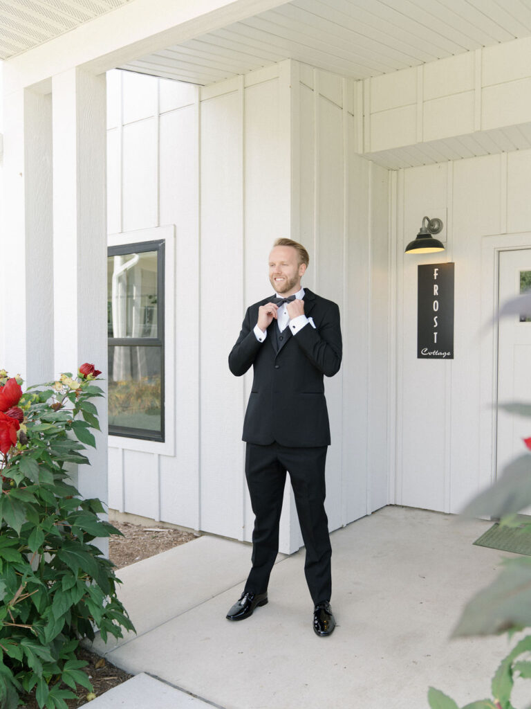 Groom standing outside the Frost Cottage Lower at Bay Pointe Inn.