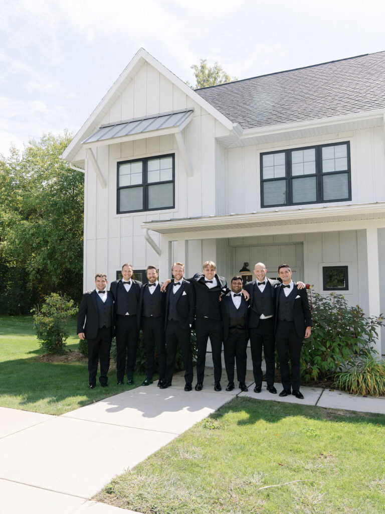 Groomsmen standing together outside the Frost Cottage Lower at Bay Pointe Inn.