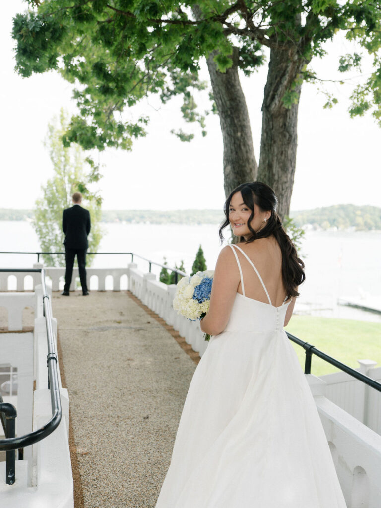 Bride walking toward her groom for their outdoor first look at Bay Pointe Woods.
