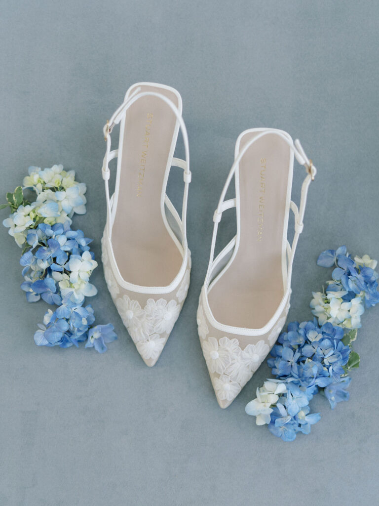 Brides wedding heels and blue florals detail shot.